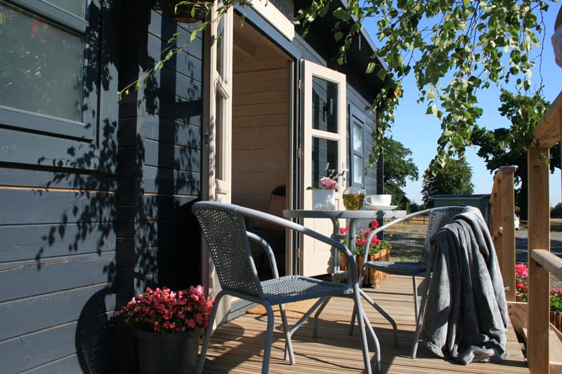 The NC Wellbeing cabin exterior with chairs on the deck