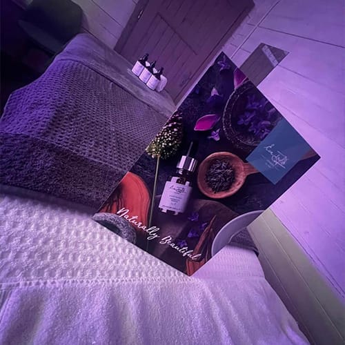 Massage bed with Eve Taylor products and purple uplighting